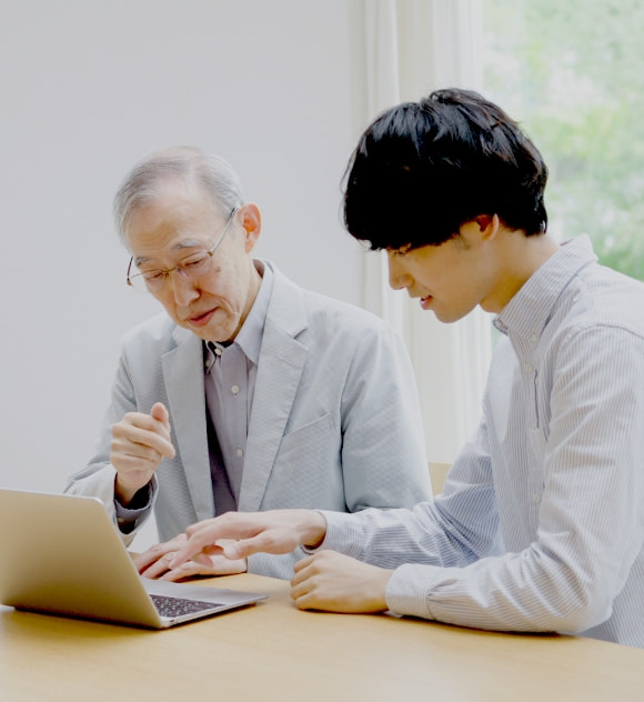 パソコンを操作する男性とおじいさん